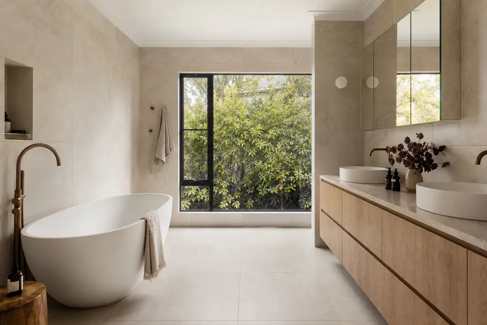 Warm neutral bathroom with freestanding bath and long timber vanity