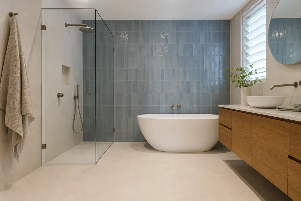 Completed bathroom with muted blue feature tiles and a freestanding bath